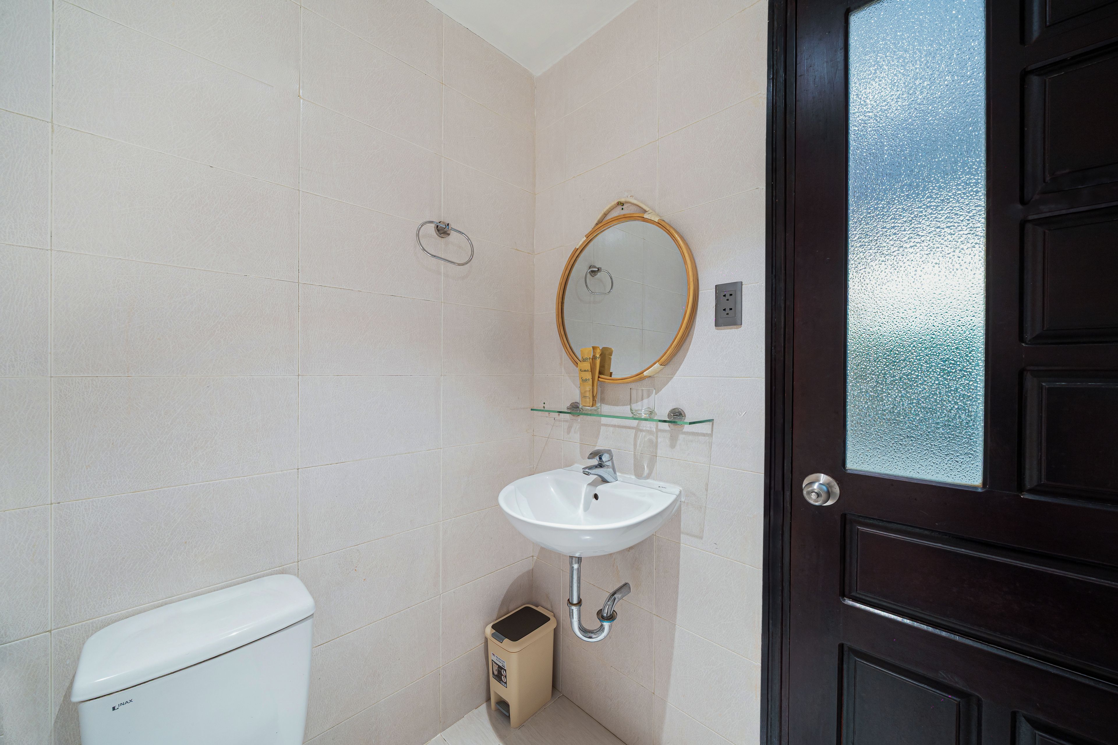 A bathroom with a toilet, sink, and mirror.
