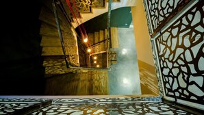 A staircase with a wooden finish and a geometric patterned wall. - Château les Gardis (Lourmarin)