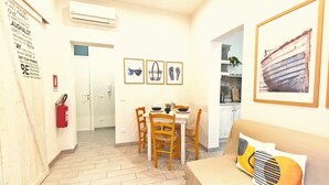 A compact living space with a dining area, a kitchen, and a seating area. - Summer House (Trapani)