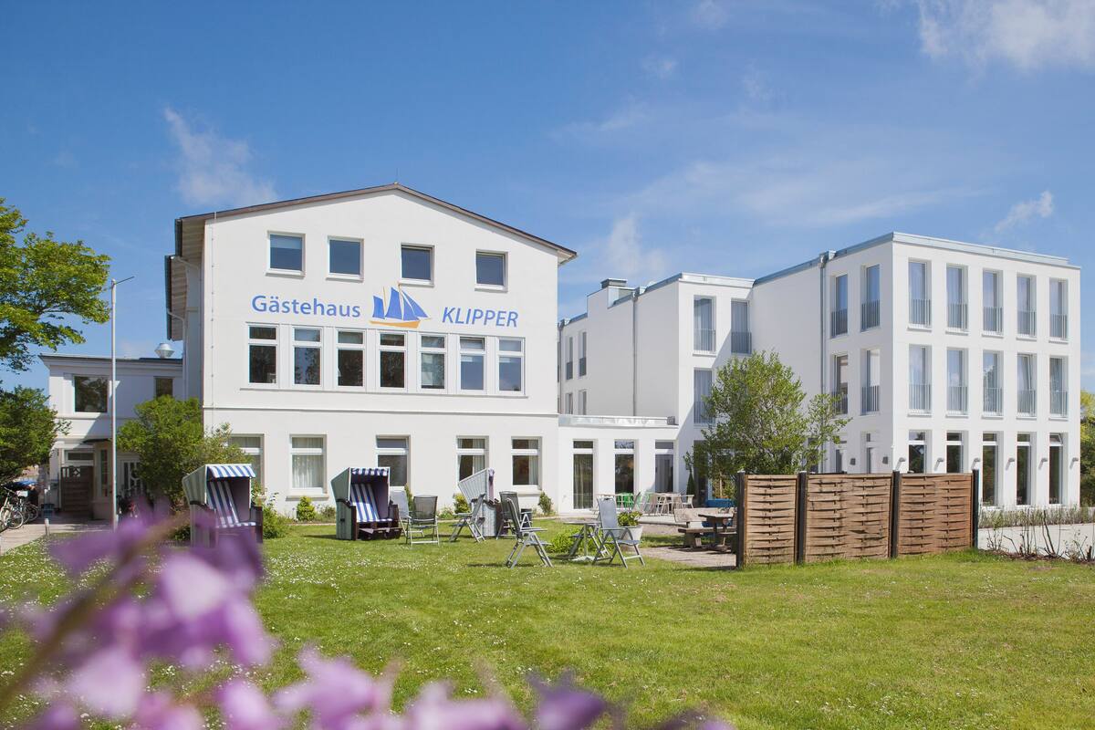 Ein modernes Gebäude mit der Aufschrift "Gästehaus KLIPPER" an der Fassade, mit zahlreichen Fenstern und einem Flachdach.