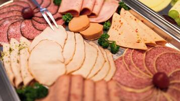 A variety of sliced meats and cheeses arranged on a platter.