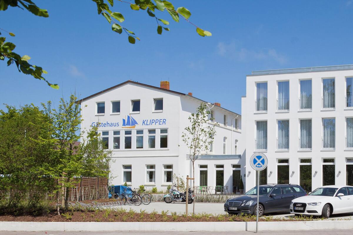 Ein modernes Gebäude mit vielen Fenstern und einem Schild mit der Aufschrift 'Gestehaus KLIPPER'.