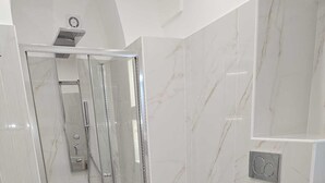 A modern bathroom with a glass-enclosed shower, a bidet, and a toilet. - 1940 Apartment (Catania)