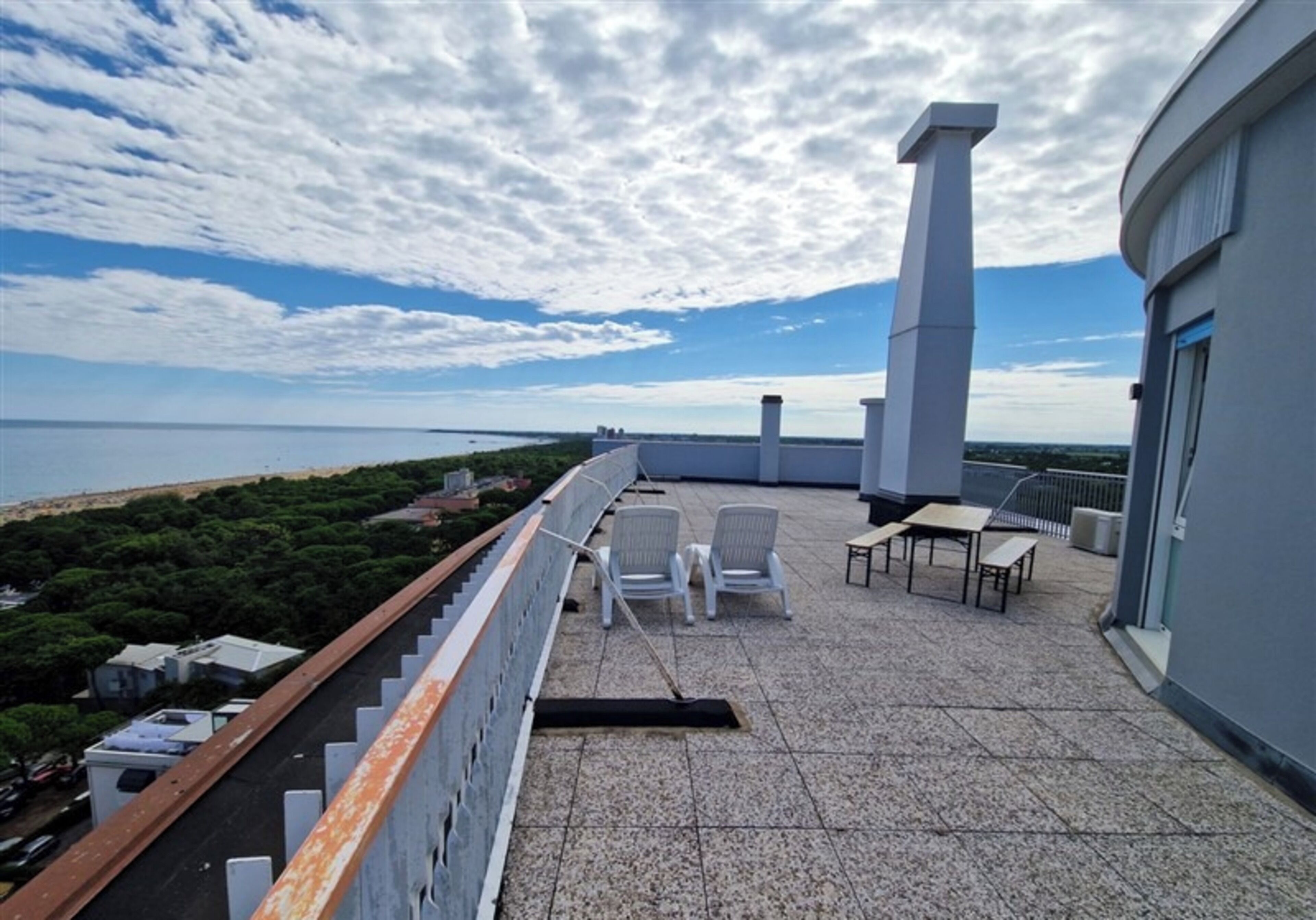Eine Dachterrasse mit Panoramablick auf das Meer, einer Pergola und Sitzmöglichkeiten im Freien.