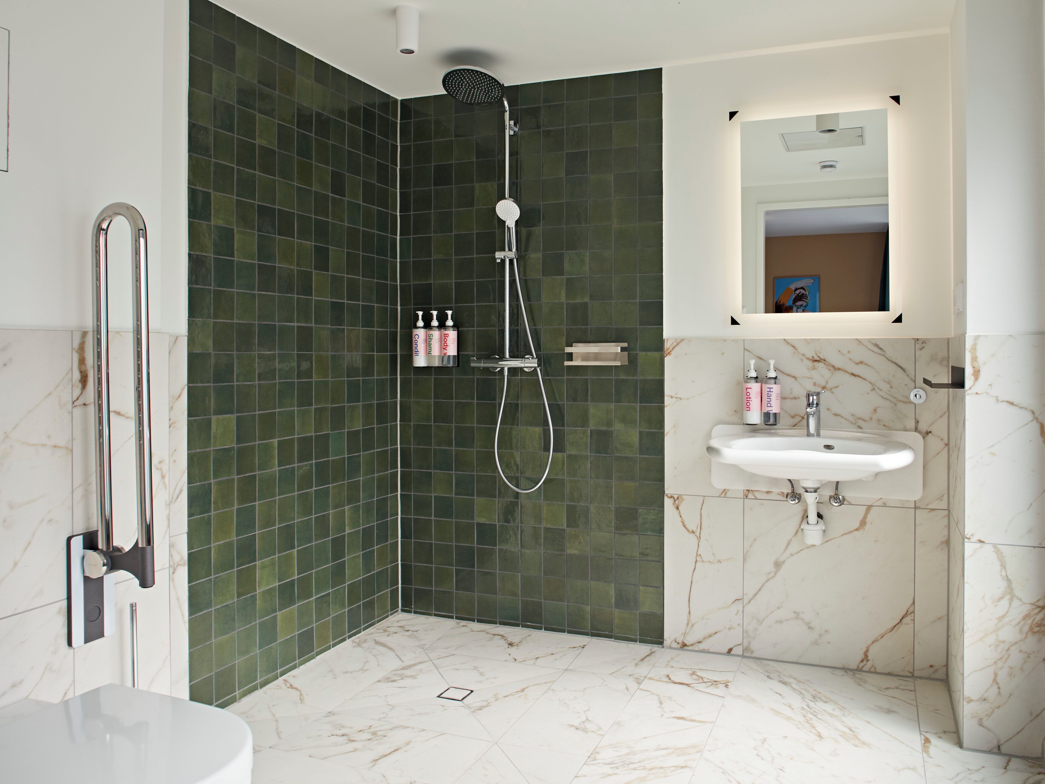 A modern bathroom with a shower, a sink, and a toilet.