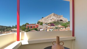 Un balcón con vistas a una colina rocosa y edificios.
