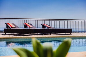 A poolside area with lounge chairs and a metal railing. - Le Mas d’Azur – Exceptional view & pool (Tourrettes-sur-Loup)