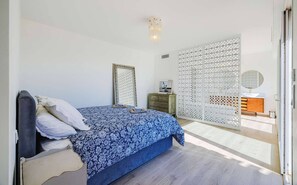 A bedroom with a bed, a dresser, a mirror, and a decorative screen. - Le Mas d’Azur – Exceptional view & pool (Tourrettes-sur-Loup)