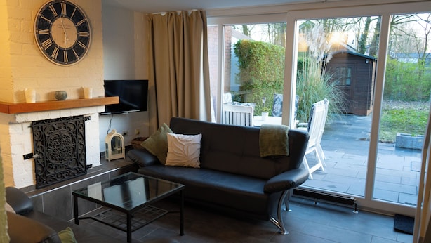 A living room with a sofa, coffee table, and a fireplace. - Vacation home with terrace in Bruinisse near Renesse for up to 6 people (Bruinisse)