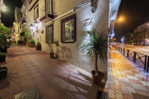 A nighttime street view with a building labeled "Tak" and potted plants along the sidewalk. - TAK Boutique Marbella Old Town with Parking (Marbella)
