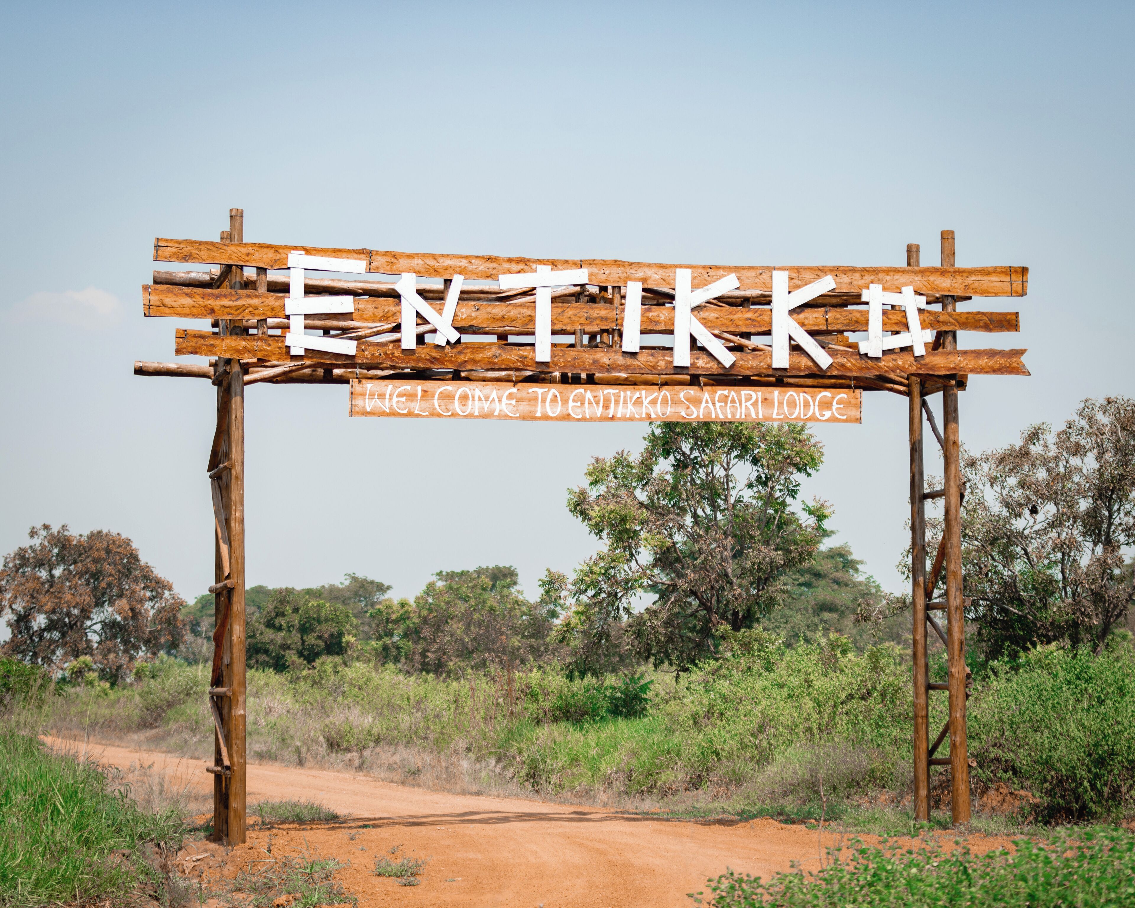 A wooden sign with the text "ENTIKKO SAFARI LODGE" welcoming visitors.