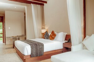 Habitación de hotel con una cama grande, una mesita de noche con lámpara y vistas al exterior.