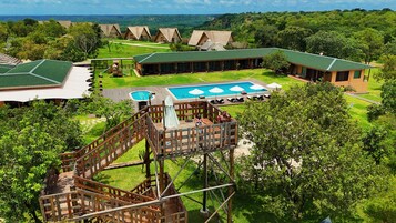 A resort with multiple bungalow-style accommodations, a central pool area, and a wooden deck structure.