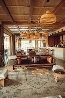 Un lobby amplio con techo de madera, sofás de cuero y una mesa de centro.