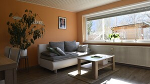 Una sala moderna con un sofá, una mesa de centro y un ventanal grande.