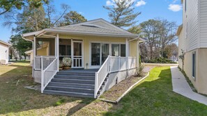A single-story house with a covered porch, a small front yard, and a clear sky.