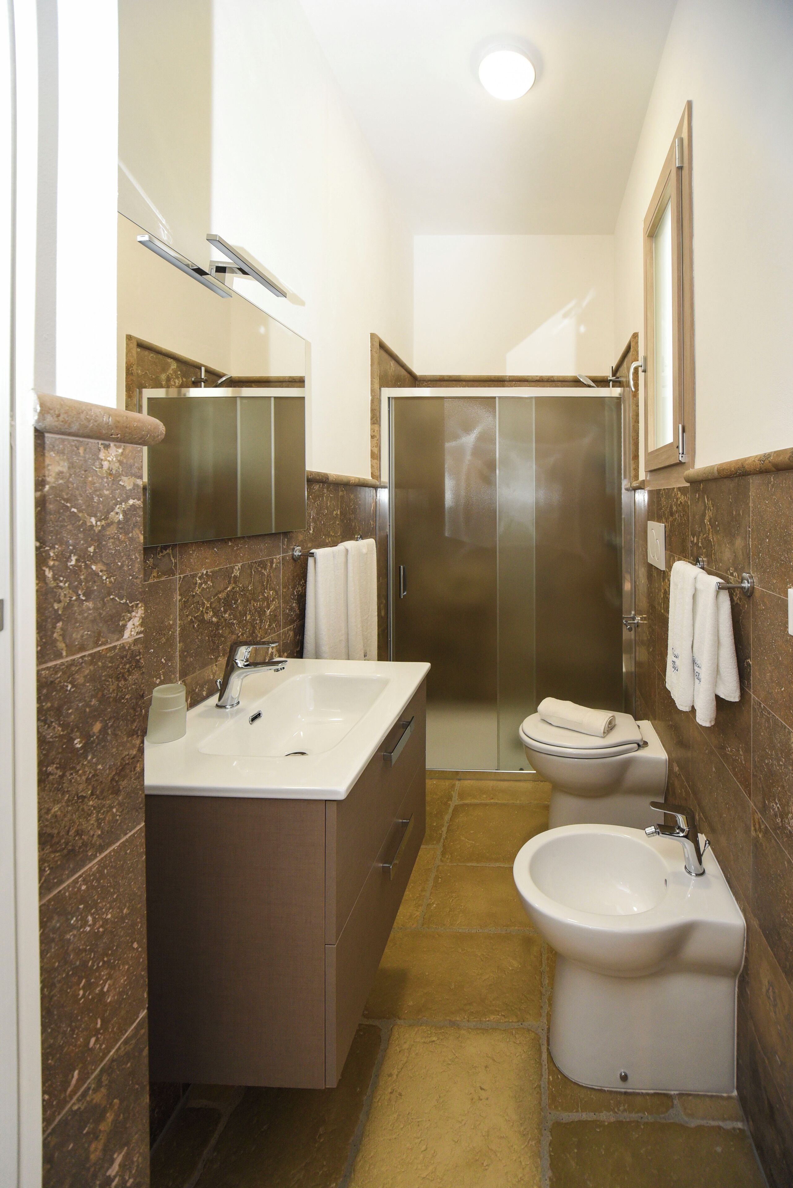 Une salle de bain équipée d’un lavabo, d’un bidet et d’une cabine de douche.