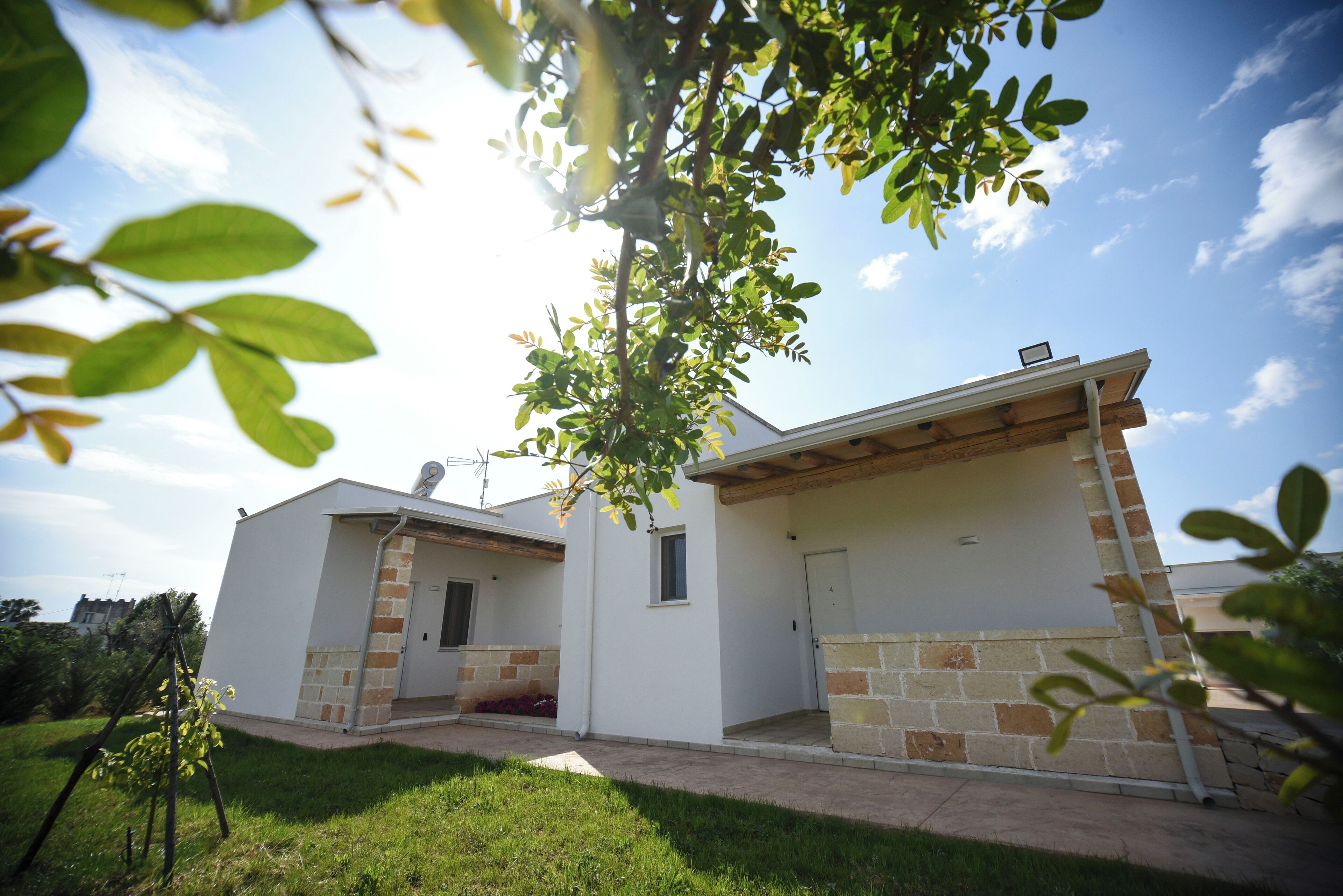 Una casa moderna de dos pisos con fachada de ladrillo y un porche cubierto.