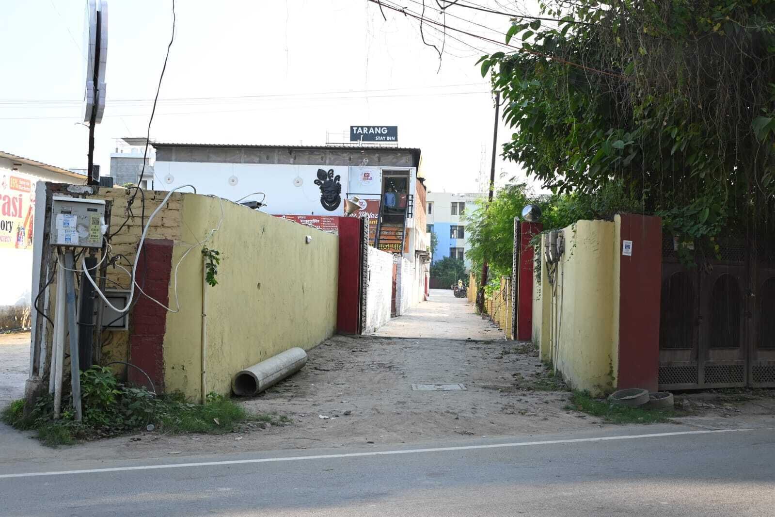 Un callejón estrecho que conduce a un edificio con un cartel que dice "TARANGN STAY INN".