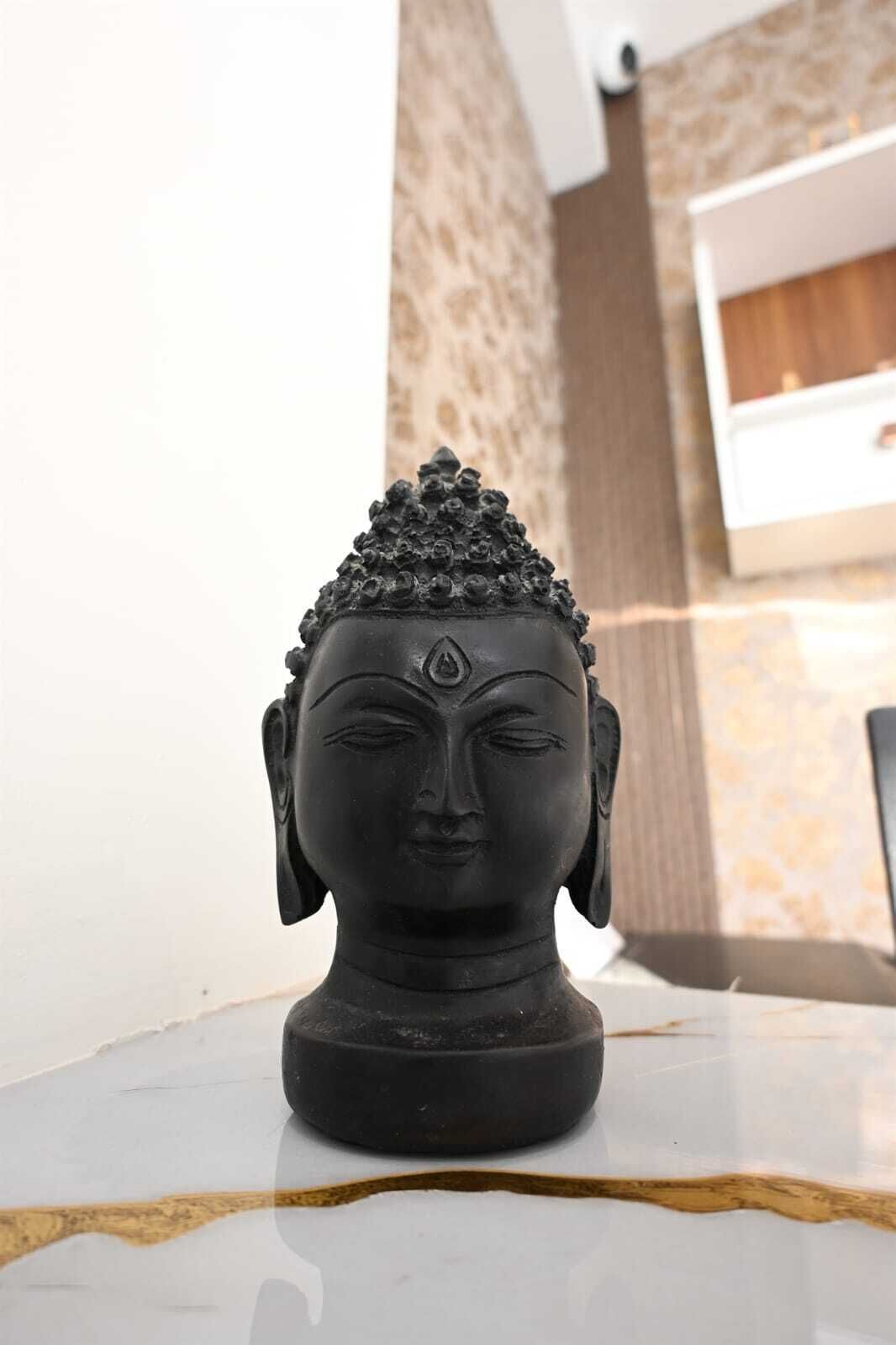 A black Buddha statue on a marble surface.