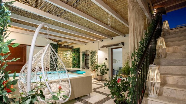 Ein Poolbereich mit einer Hängematte, einer Treppe und Topfpflanzen.
