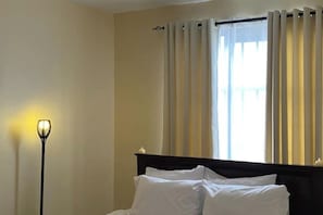 A hotel room with a bed, a nightstand, and a floor lamp. - Airport view Utawala 2 bdr (near JKIA)@0703500856 (Nairobi County)