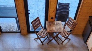 A wooden staircase leading to a dining area with a table and chairs. - Aparan park (Yeghipatrush)