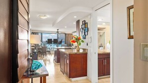 A modern kitchen with dark wood cabinets, a granite countertop, and a central island. - Top Notch Rental Experience Awaits! (Lahaina)