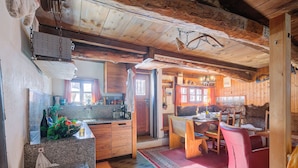 A rustic kitchen with granite countertops, wooden cabinets, and a red rug. - Rustico Al Museo Bosco Gurin for 6 (Bosco Gurin)