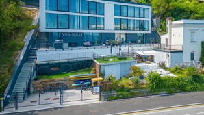 A modern building with a visible restaurant named 'Vila Molet' and outdoor seating. - Romantični Studio ob Morju Koper (Koper)