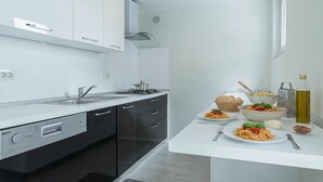 A modern kitchen with a built-in dishwasher, a stove, and a sink. - Romantični Studio ob Morju Koper (Koper)