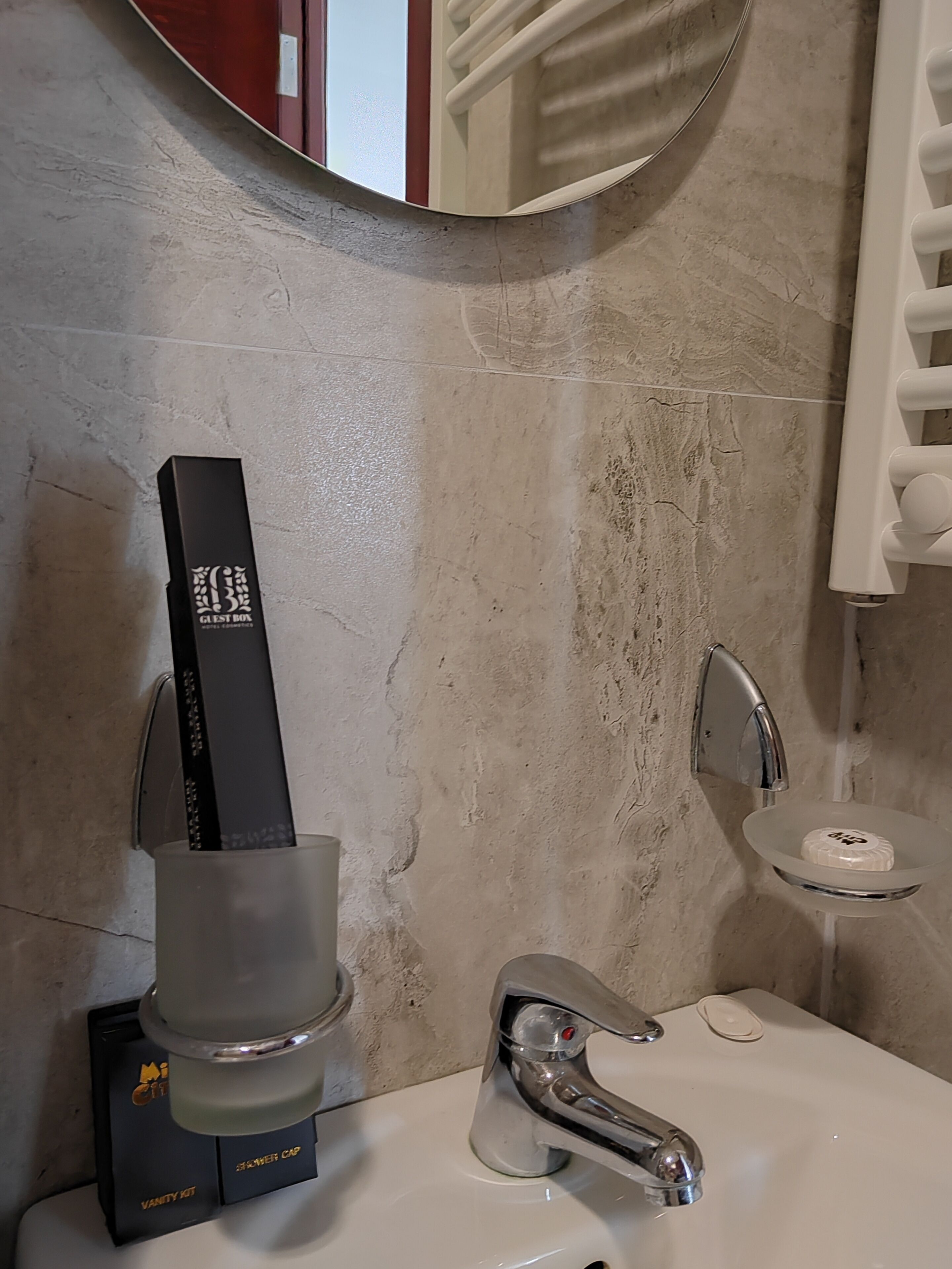 A bathroom with a white sink, chrome faucet, and a towel rack.