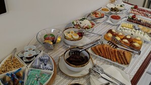 A buffet table with various dishes and condiments. - Mio City Hotel (Kula)