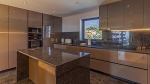 Una cocina moderna con encimeras de granito, electrodomésticos de acero inoxidable y un amplio ventanal con vistas a la ciudad.