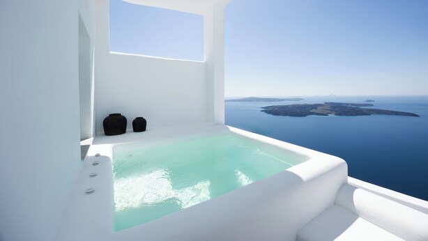 Un bagno moderno e minimalista con una vasca da bagno ampia e vista mare.