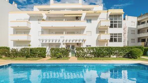 A modern building with a swimming pool in front.