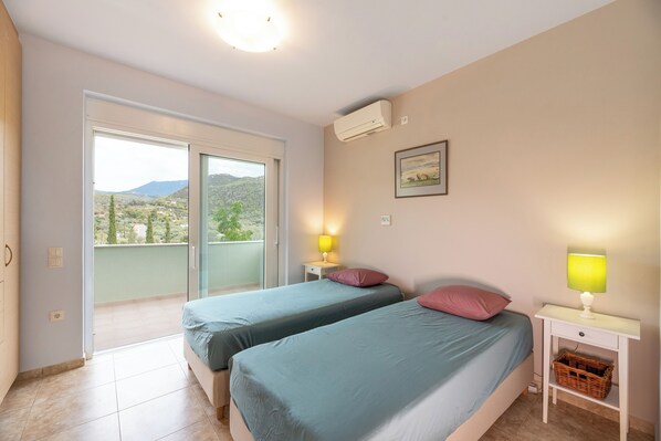 Un dormitorio con dos camas, un balcón y vistas al campo.