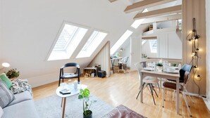 A spacious loft apartment with a dining area, a kitchen, and a living room. - Urban Apartment - City Center (Bergen)