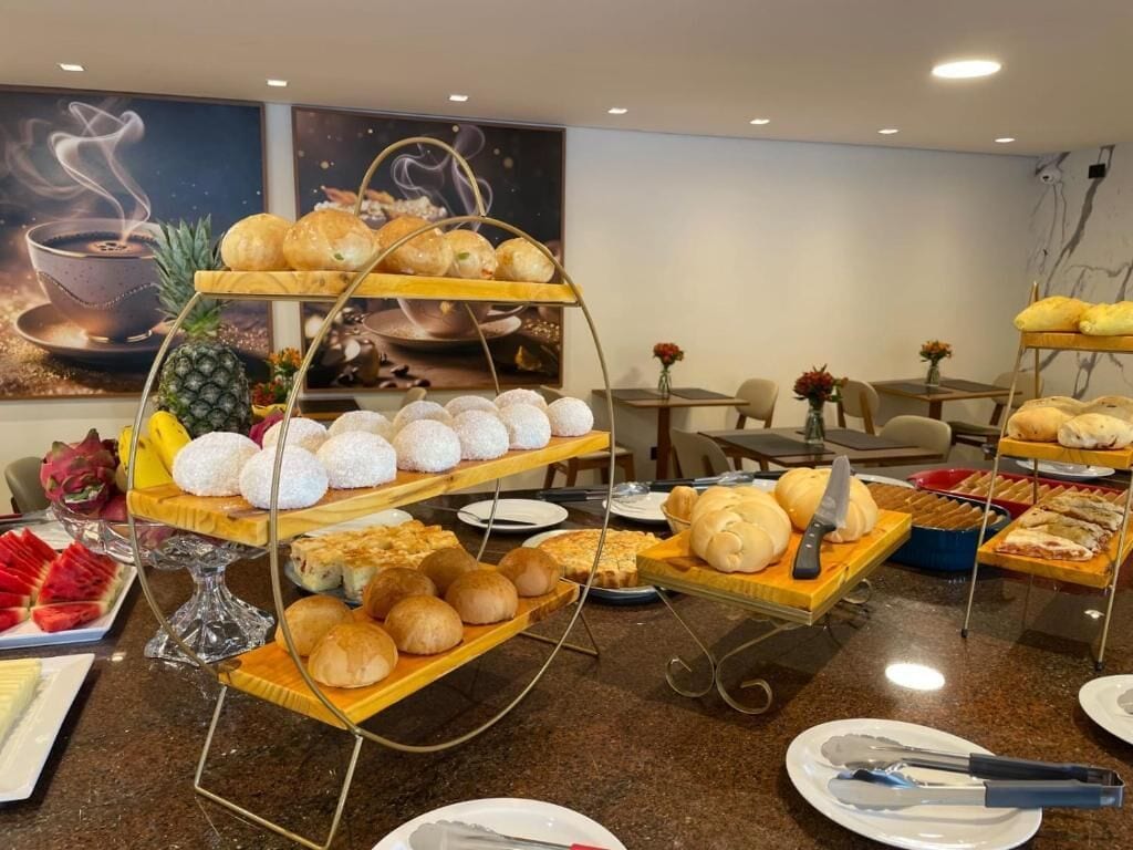 Un buffet proposant une variété de pâtisseries, de fruits et un gâteau présenté sur des présentoirs à étages.