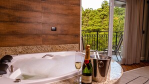 A spa area with a hot tub, a bottle of champagne, and a glass on a granite countertop. - Champet Boutique Hotel (Campos do Jordão)