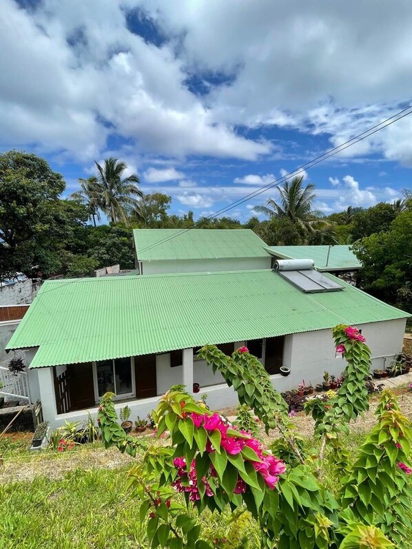 A two-story building with a green roof and a balcony.