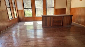 A room with wooden flooring, large windows, and a wooden cabinet. - Peaceful Entire 4 BR 2 BA Cabin with AC, WiFi, Pond  View, Recreational room (Crisfield)