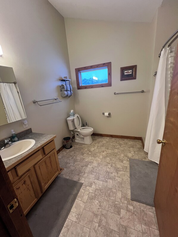 A bathroom with a sink, toilet, and window. - Near Stickney Creek boat launch-2 bedroom, 2 full bath house with private pond. (Craig)