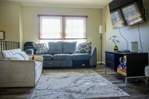 Relax in this stylish living room with a sofa, armchair, and flat-screen TV.