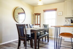 Enjoy meals in this dining area with a wooden table and comfortable chairs.
