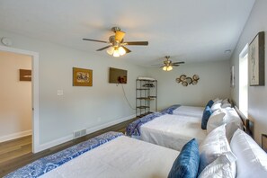A hotel room with three beds, ceiling fans, and artwork on the walls. - Group Getaway in Cadillac MI W/ Theater Room (Cadillac)