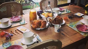 A breakfast table set with plates, cups, and a variety of food items. - L'Ecrin de l'Océan 80 m de la mer (Le Pouliguen)