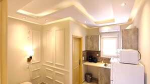 A compact kitchen with a microwave, coffee maker, and a trash bin. - Villa Miltiadis GreeceFiloxenia (Volos)