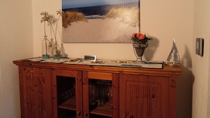 A wooden cabinet with a painting of a beach scene above it. - Vacation home with great garden and kitchen in Bruinisse near Renesse private park (Bruinisse)
