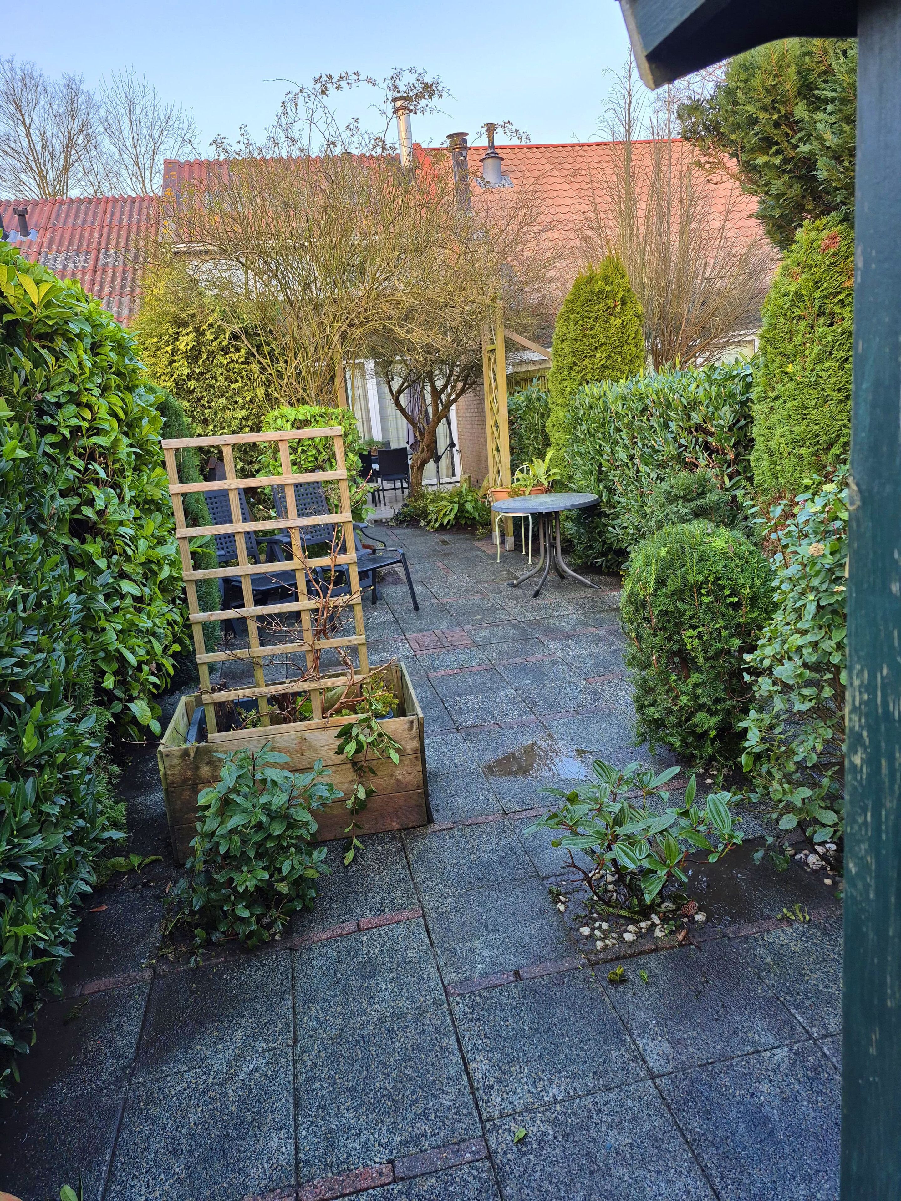 En møbleret patiohave med træterrasse, bord og stole.